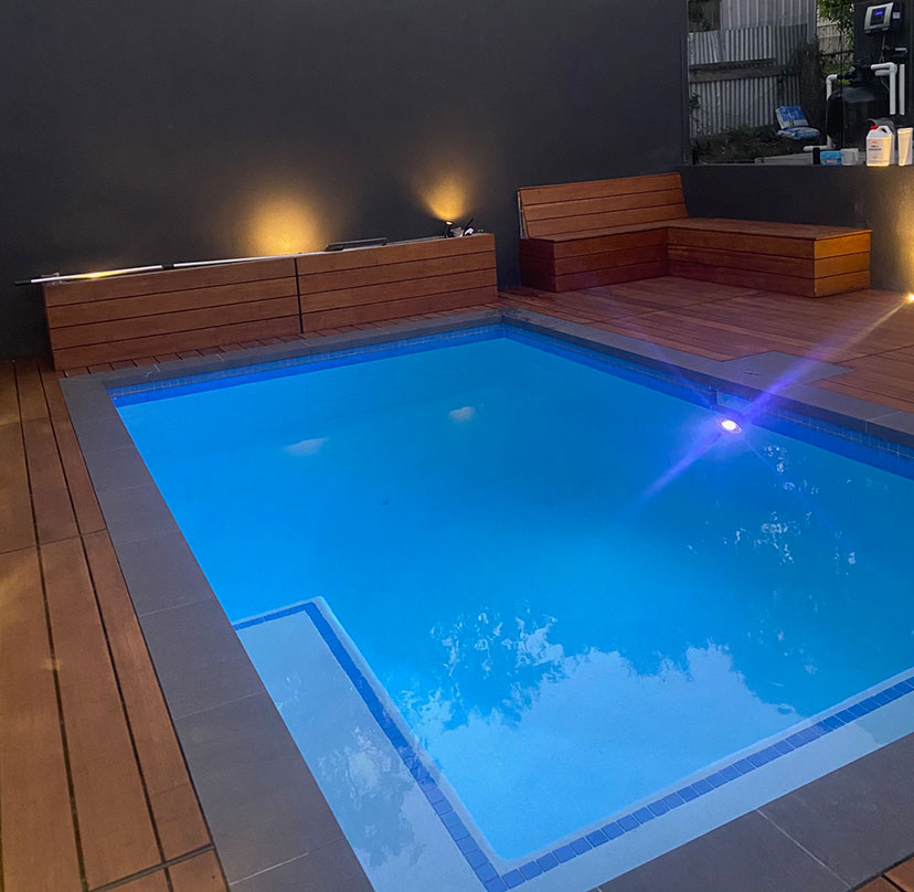concrete pool with timber deck surrounding